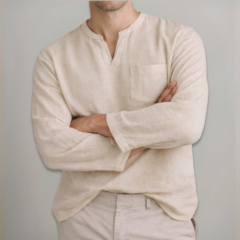 Man wearing a beige long-sleeve shirt with a pocket against a gray background