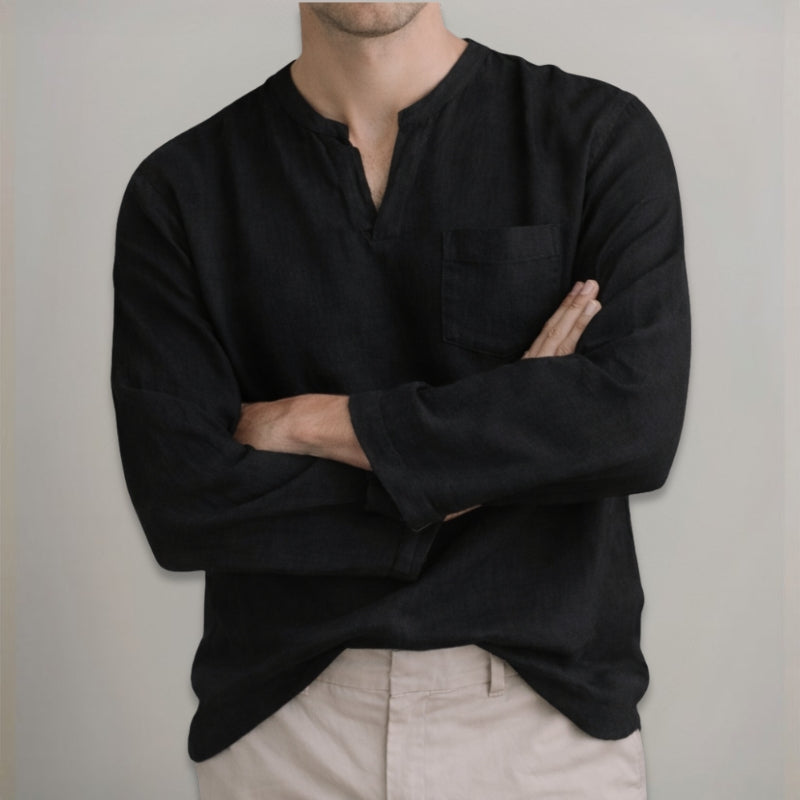 Person wearing a black long-sleeve shirt with a neutral background