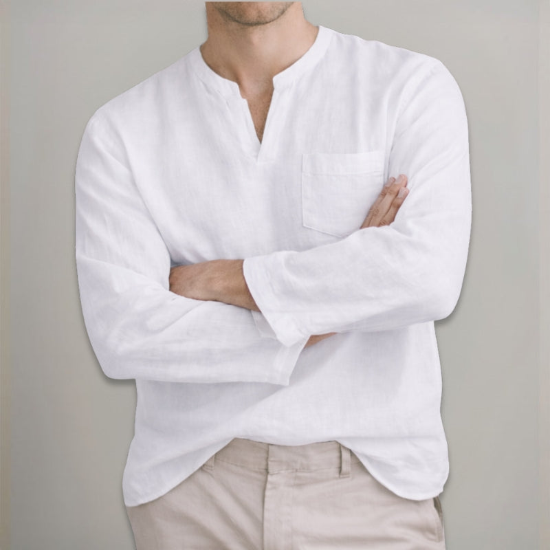 Person wearing a white long-sleeve shirt with a plain background