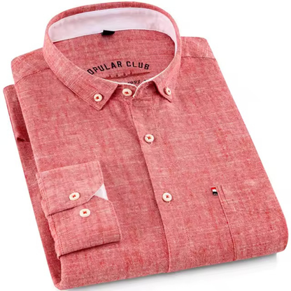 Folded salmon red shirt with brand logo on a white background