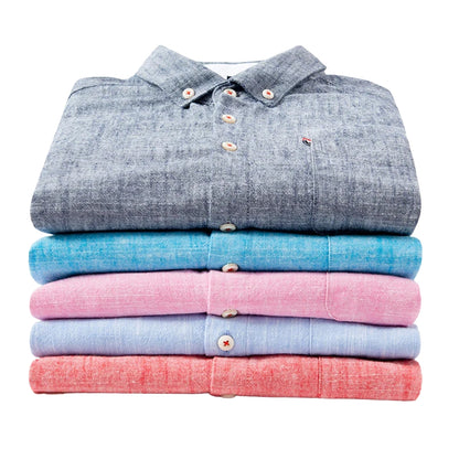 Stack of folded shirts in gray, blue, red, and red on a white background