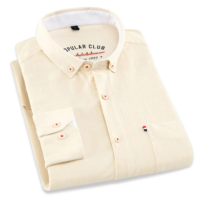 Folded beige shirt with a visible brand label on a white background