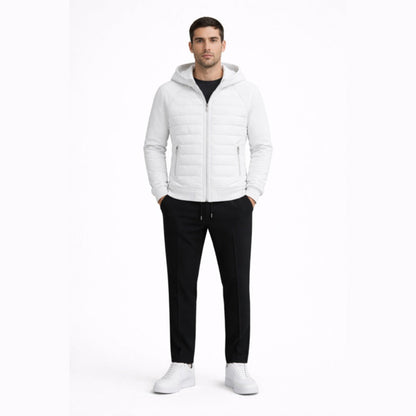 Man wearing a white quilted jacket, black pants, and white shoes on a white background