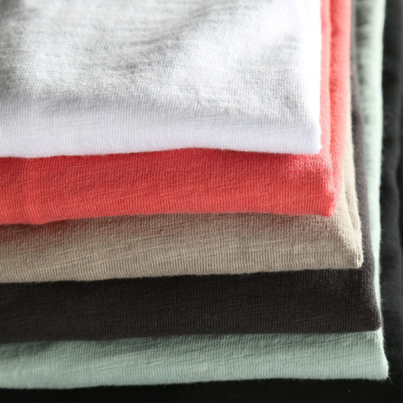Stack of folded shirts in various colors.