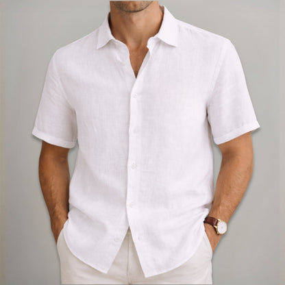Man wearing a white short-sleeve shirt against a gray background
