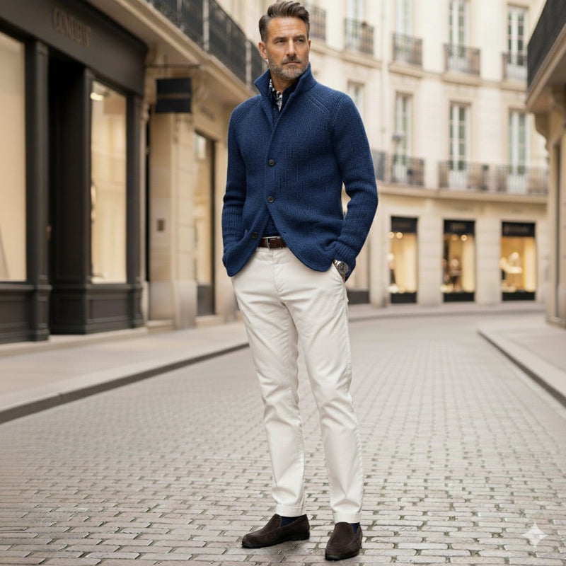 Elegant man styled in blue Alfredo Gentleman Cardigan and beige trousers, European city background