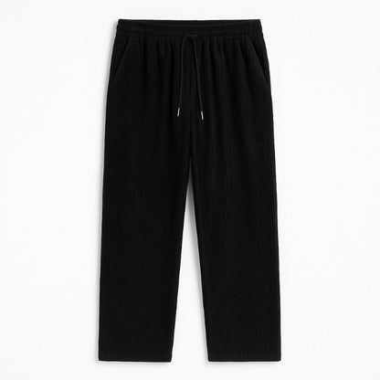 Emanuele Corduroy Pants in black – minimalist men's corduroy trousers with adjustable drawstring waist, flat presentation by Polumi.