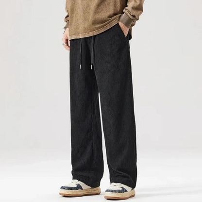 Emanuele Corduroy Pants in black – soft corduroy men's pants featuring elastic waistband and loose silhouette by Polumi.
