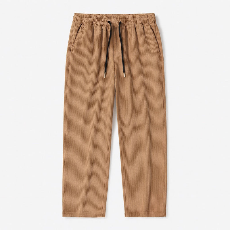Alt text:
Emanuele Corduroy Pants in brown – men's soft corduroy pants with elastic waistband and relaxed fit, flat lay view by Polumi.