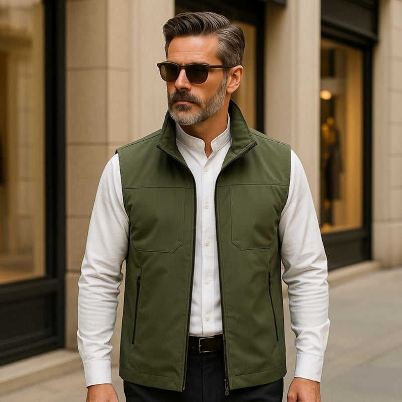 Man wearing Ennio Zip Adapt Vest in Green over a white shirt walking in a city environment