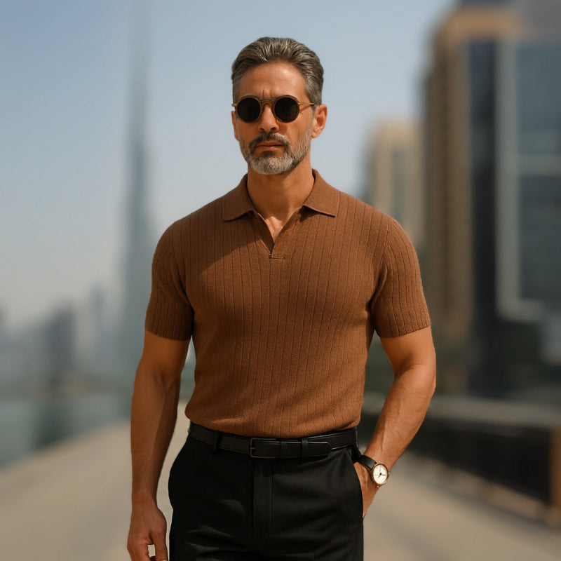Mature man wearing brown Ermenegildo Flex Knitted Polo near Dubai skyline, modern and elegant summer look by Polumi.