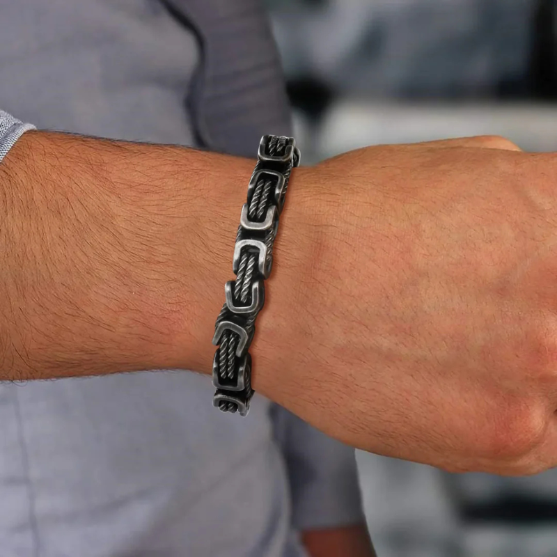 Gunmetal men’s rope chain bracelet with square links worn on wrist with shirt, elegant accessory for refined casual look.