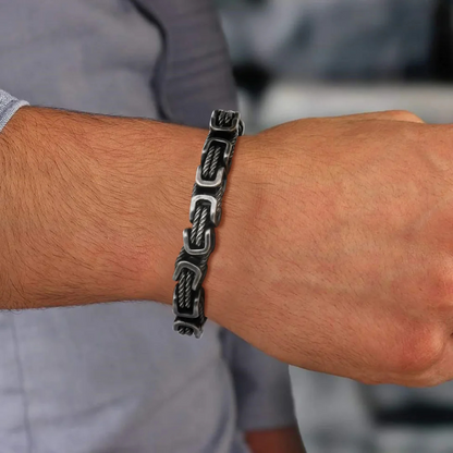 Gunmetal men’s rope chain bracelet with square links worn on wrist with shirt, elegant accessory for refined casual look.