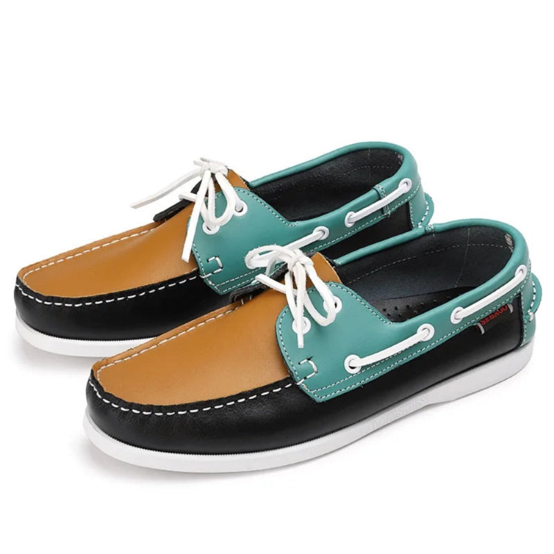 Pair of men’s leather boat shoes in multicolor design with teal, tan, and black leather panels, stylish nautical moccasins with white sole.