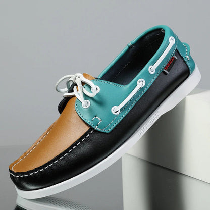 Men’s leather boat shoes in multicolor design – tan, teal, and black panels with white sole, modern nautical moccasins.