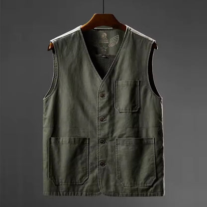 Green vest with buttons on a hanger against a gray background