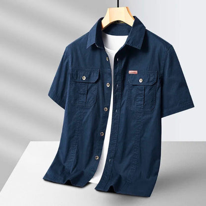 Men’s short sleeve casual shirt in navy blue with front pockets and button closure.