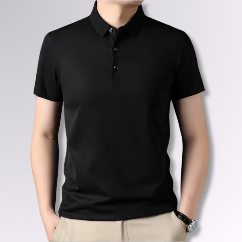 Men’s black polo shirt with short sleeves, slim fit, styled with beige trousers.