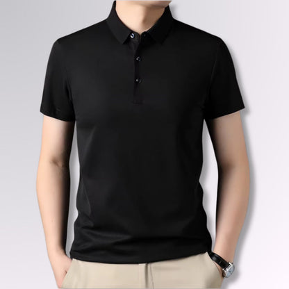 Men’s black polo shirt with short sleeves, slim fit, styled with beige trousers.
