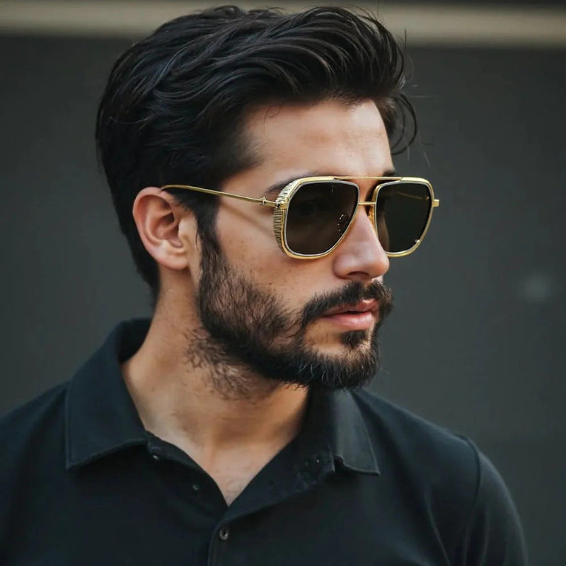 Stylish man wearing golden aviator sunglasses with black lenses, elegant and modern eyewear look.