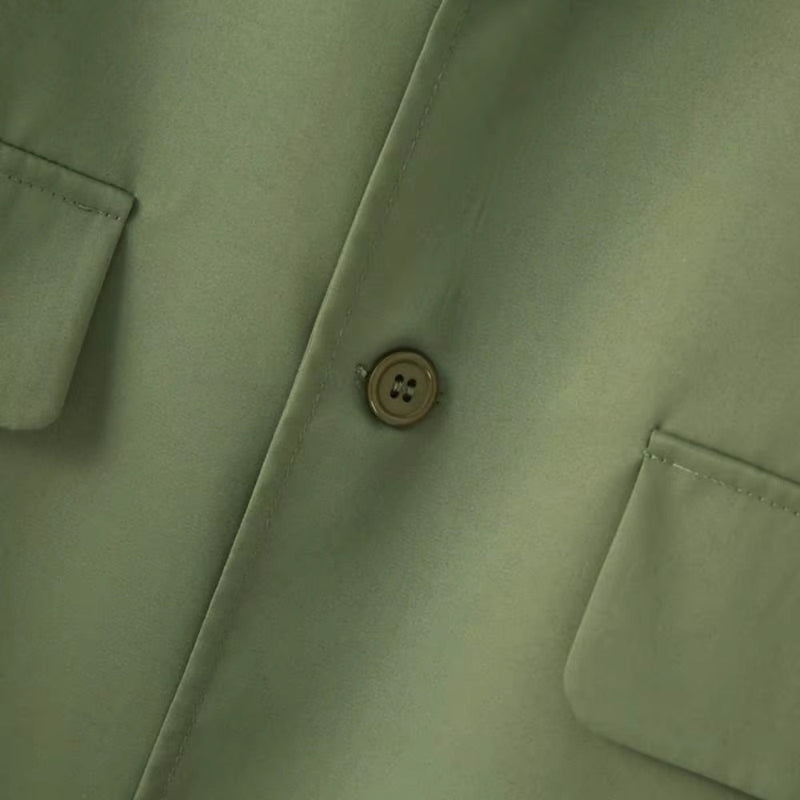 Close-up detail of blazer button and pocket on Torino Men’s Soft Suit in army green.
