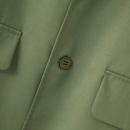 Close-up detail of blazer button and pocket on Torino Men’s Soft Suit in army green.

